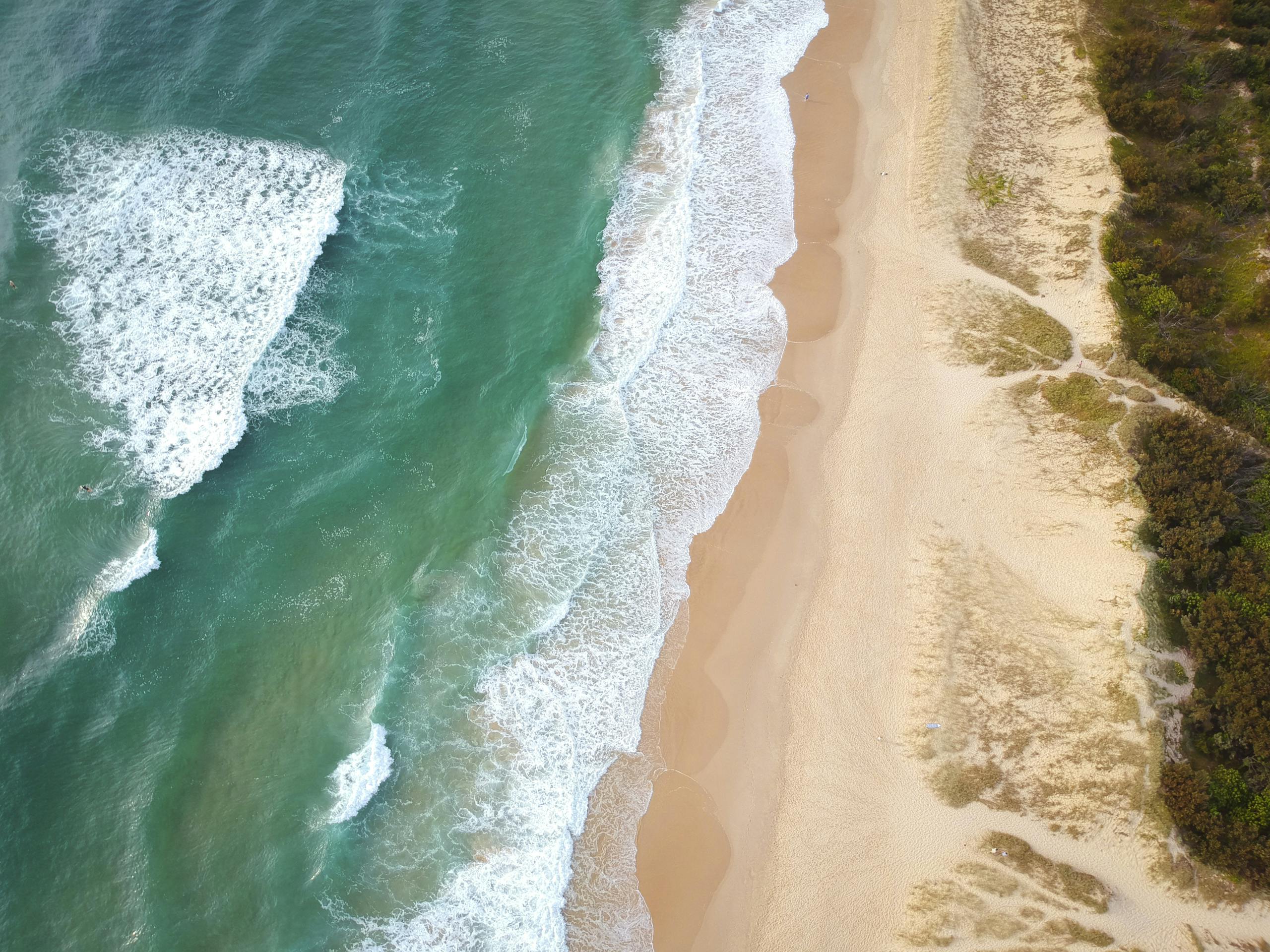 Stunning aerial view of the serene Castaways Beach with turquoise waters and golden sands.